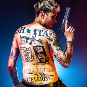 portret wytatuowanego zawodnika IPSC z bronią